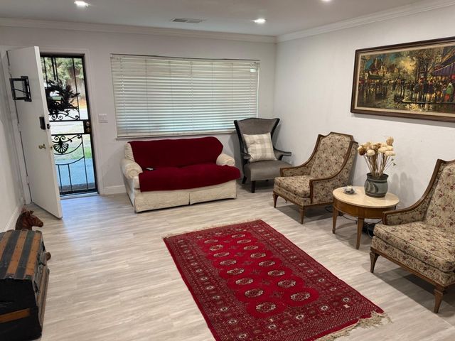 a living room with furniture and wooden floor