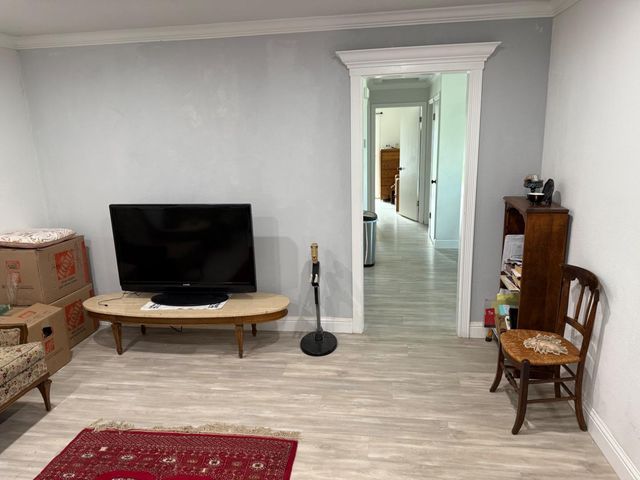 a living room with patio furniture and a flat screen tv