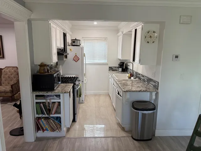 a kitchen with a stove and a wooden floor