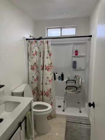 a bathroom with a sink a toilet and shower curtain