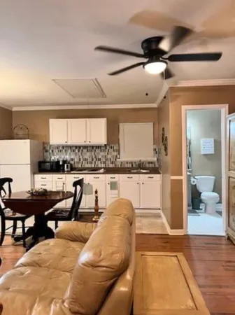 a living room with lots of furniture and view of kitchen