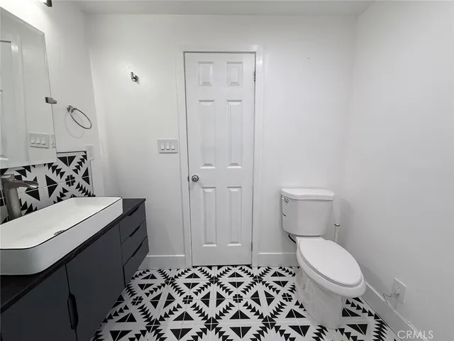 a bathroom with a sink and mirror with toilet