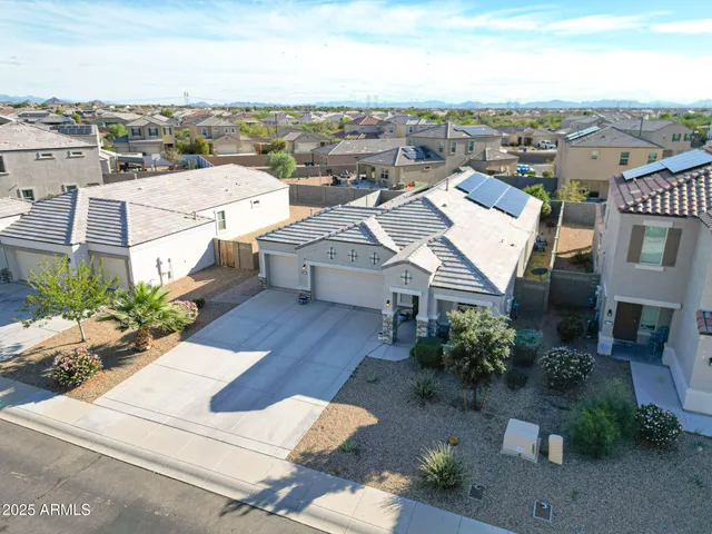 an aerial view of a house with a yard garage and lake view in back