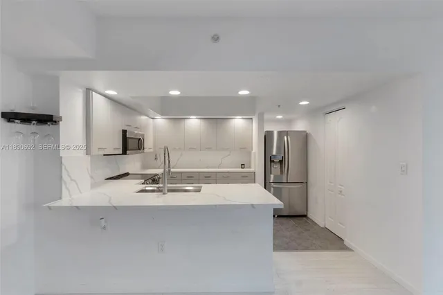 a view of kitchen with a sink stainless steel appliances and cabinets