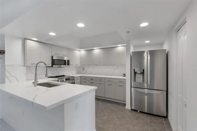 a kitchen with stainless steel appliances a refrigerator sink and microwave