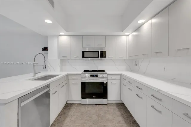 a kitchen with white cabinets stainless steel appliances and sink