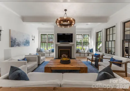a living room with furniture a large window and a fireplace