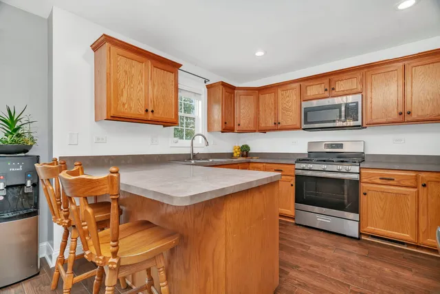 a kitchen with kitchen island granite countertop a sink cabinets and wooden floor