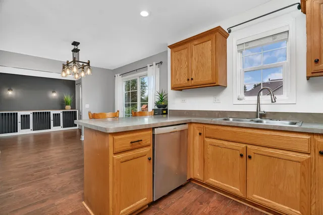 a kitchen with stainless steel appliances granite countertop a sink dishwasher and cabinets with wooden floor