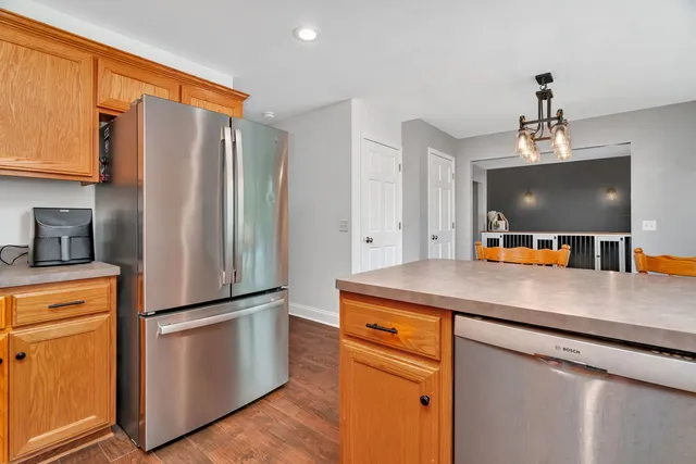 a kitchen with stainless steel appliances granite countertop white cabinets and a stove top oven