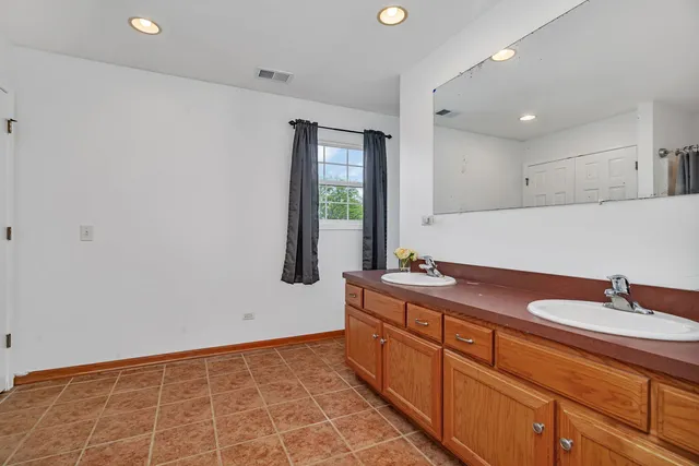 a spacious bathroom with a toilet sink and mirror