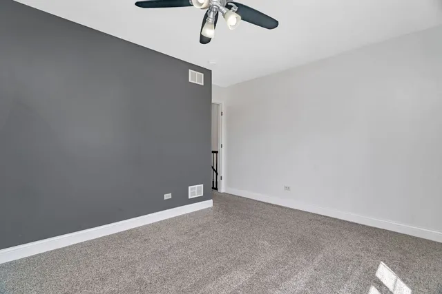 a bedroom with bed and a painting on the wall