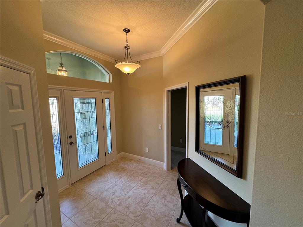 2276 Fringe Tree Trail The Villages, FL 32162 - Photo 3 of 22 a view of a hallway with a large window and chandelier