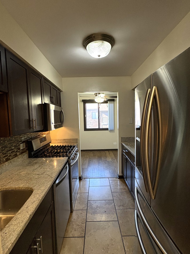15805 Peggy Lane, Unit 9 Oak Forest, IL 60452 - Photo 4 of 20 a kitchen with stainless steel appliances granite countertop a sink stove and refrigerator