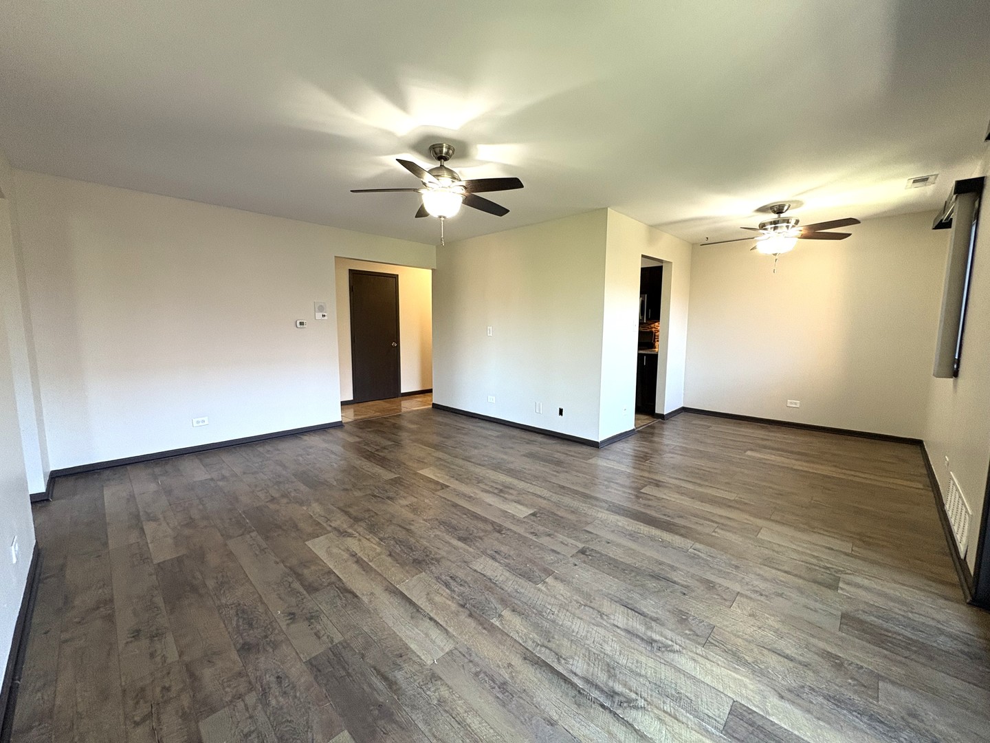 15805 Peggy Lane, Unit 9 Oak Forest, IL 60452 - Photo 8 of 20 an empty room with wooden floor chandelier fan and windows