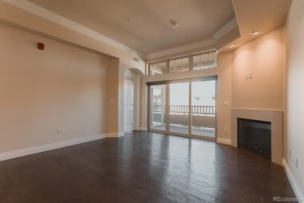 an empty room with wooden floor and fireplace