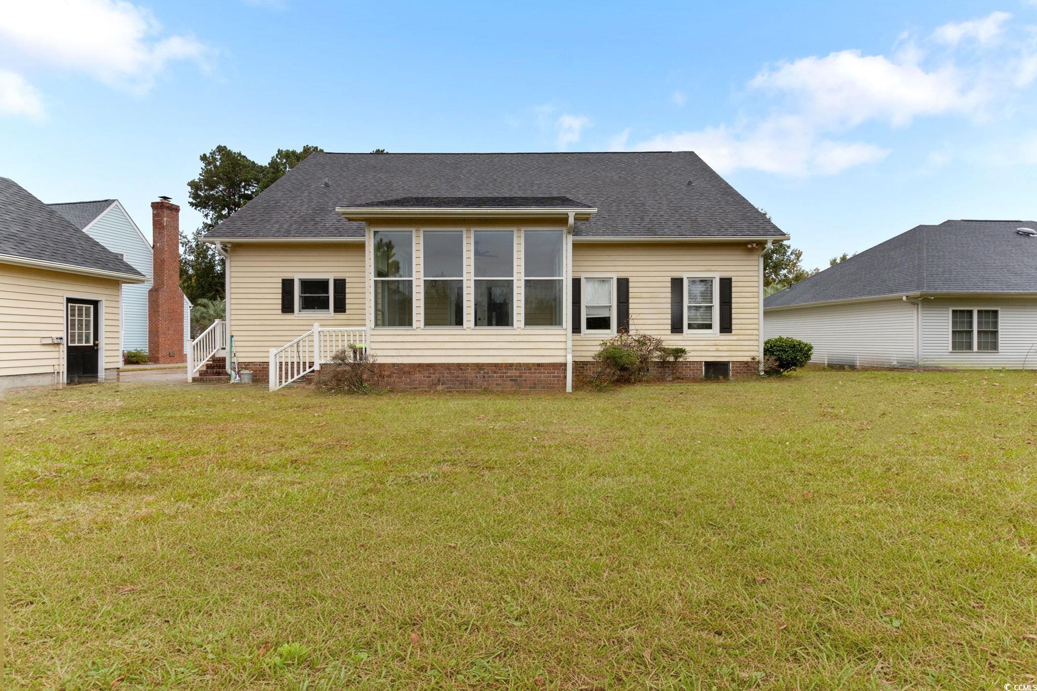 2321 Brick Drive Longs, SC 29568 - Photo 4 of 40 Back of property with a sunroom, a lawn, and a shingled roof