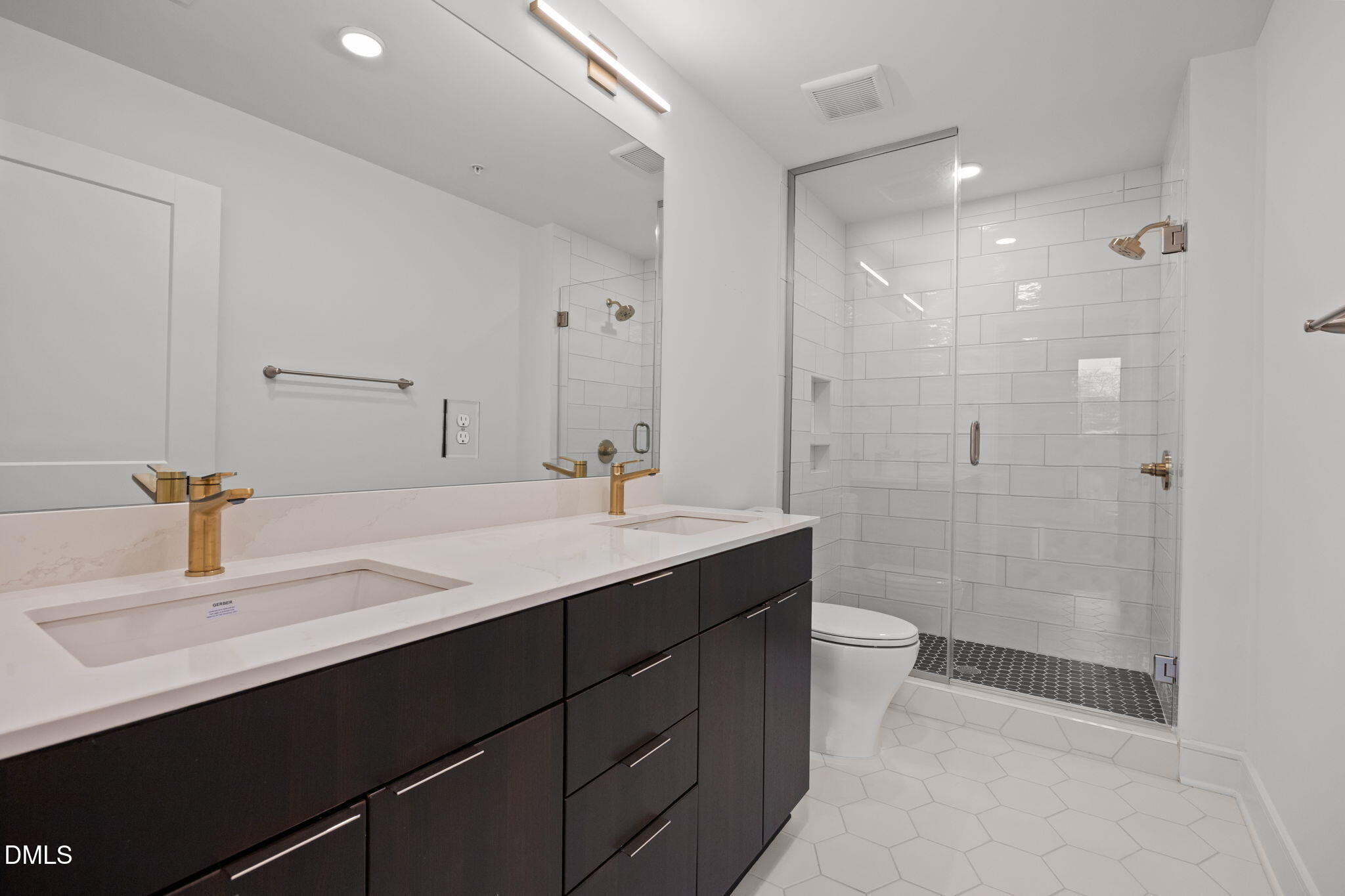 615 West Peace Street, Unit 307 Raleigh, NC 27605 - Photo 16 of 20 a bathroom with a double vanity sink toilet and shower