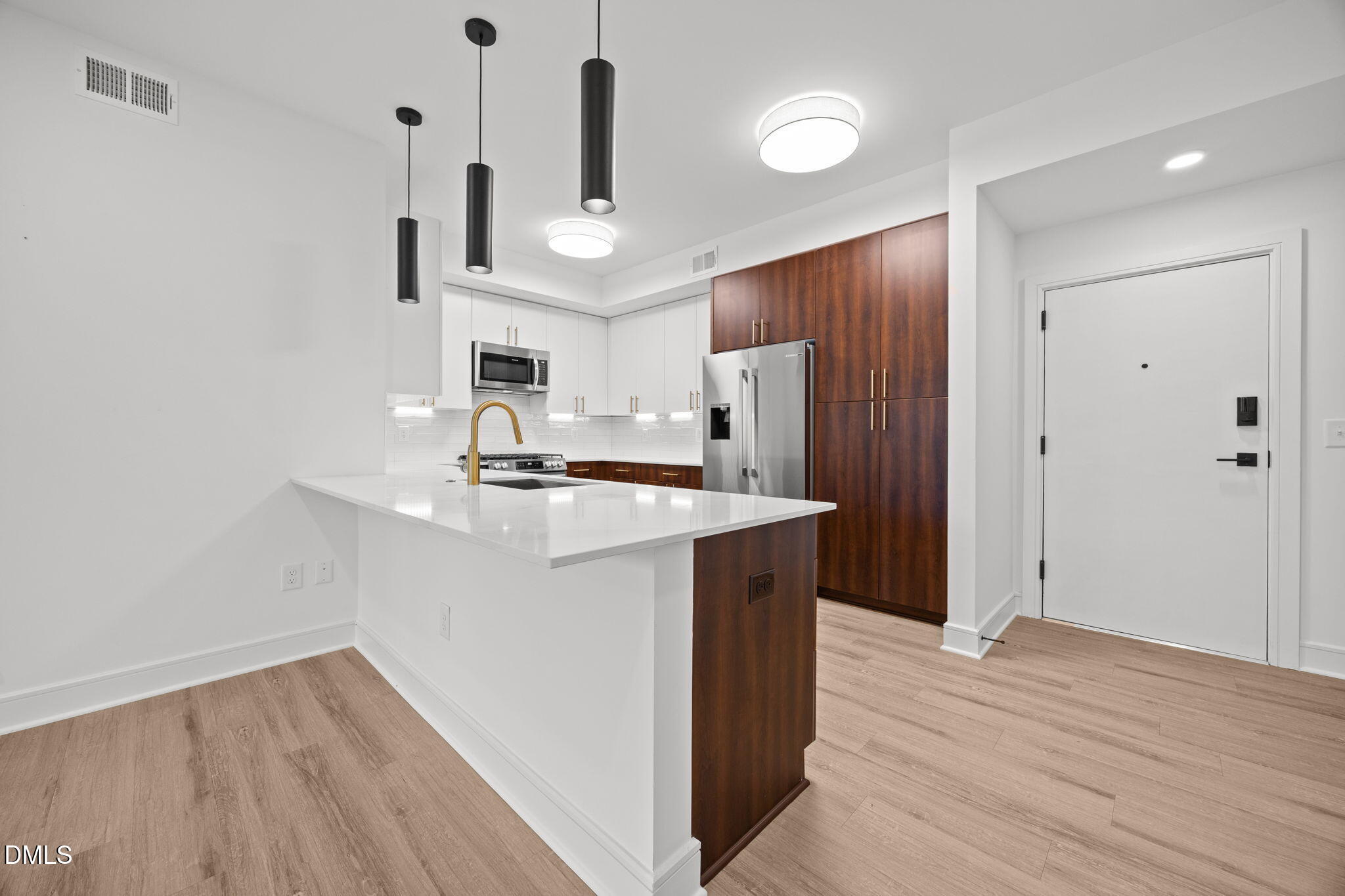 615 West Peace Street, Unit 307 Raleigh, NC 27605 - Photo 5 of 20 a kitchen with kitchen island white cabinets and stainless steel appliances