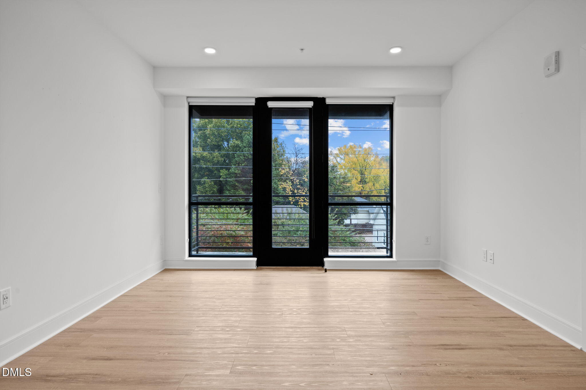 615 West Peace Street, Unit 307 Raleigh, NC 27605 - Photo 6 of 20 a view of an empty room with wooden floor and a window