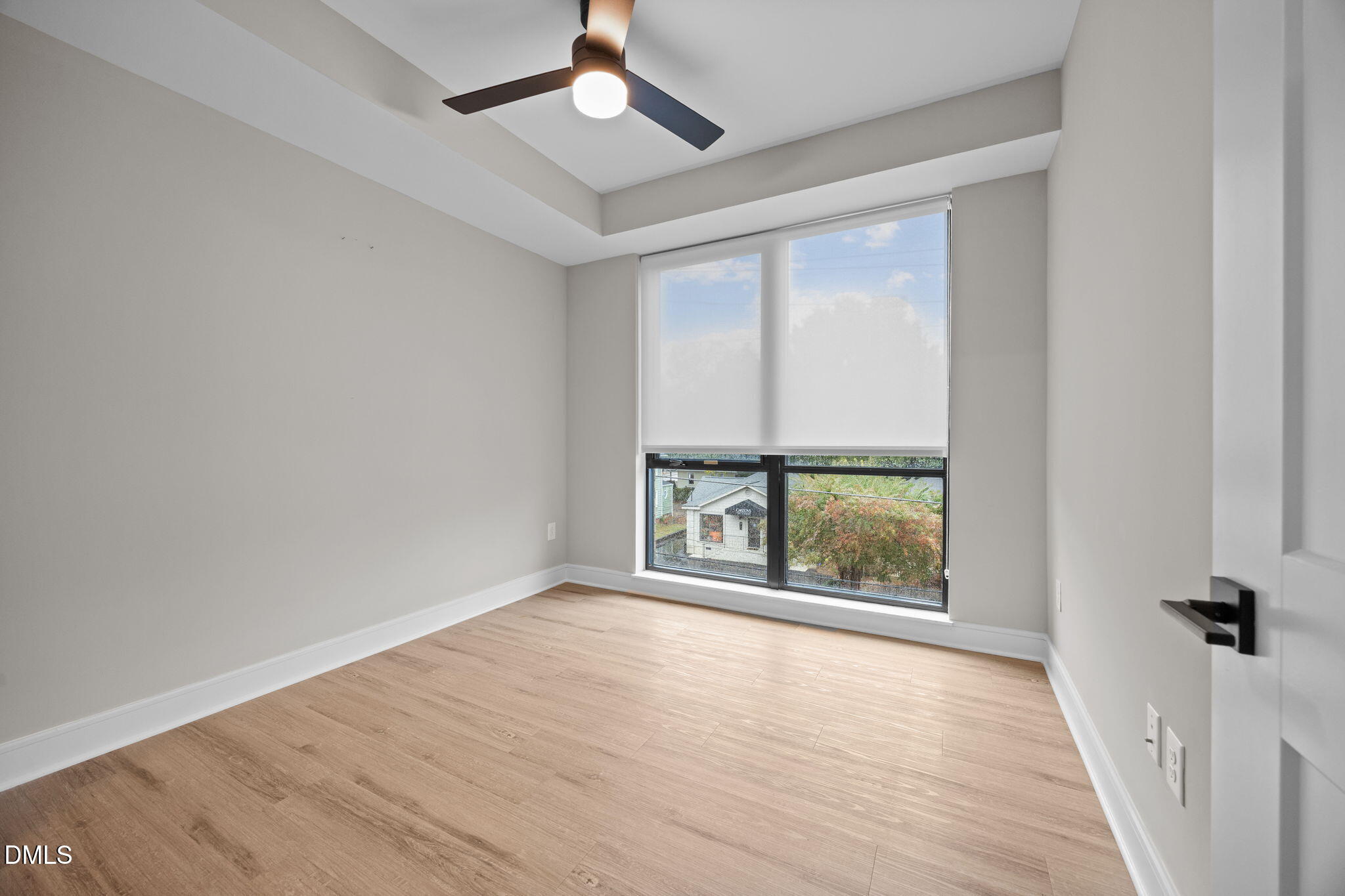 615 West Peace Street, Unit 307 Raleigh, NC 27605 - Photo 9 of 20 an empty room with wooden floor fan and windows