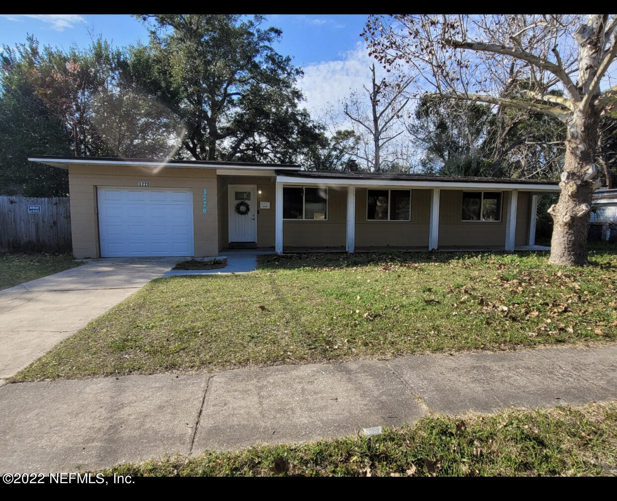 a front view of house with yard and trees in the background