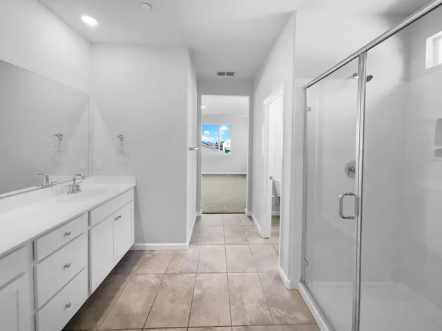 a bathroom with a double vanity sink and shower