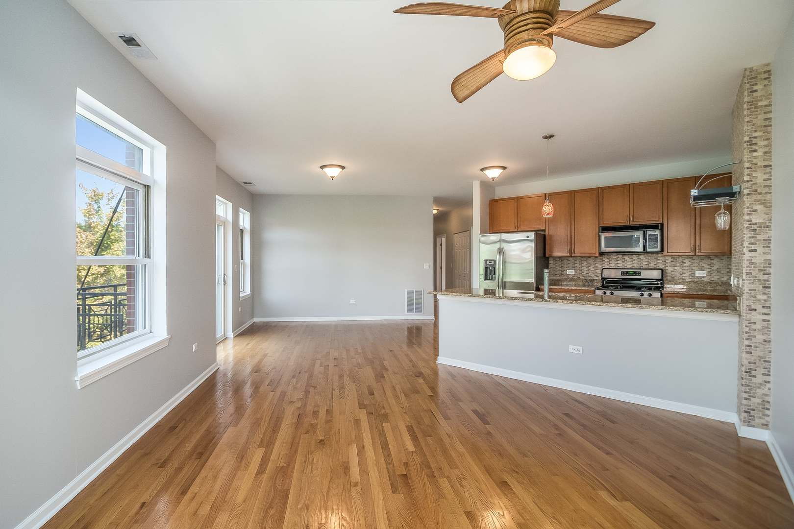 1461 South Halsted Street, Unit 3B Chicago, IL 60607 - Photo 5 of 21 a view of kitchen and empty room with wooden floor