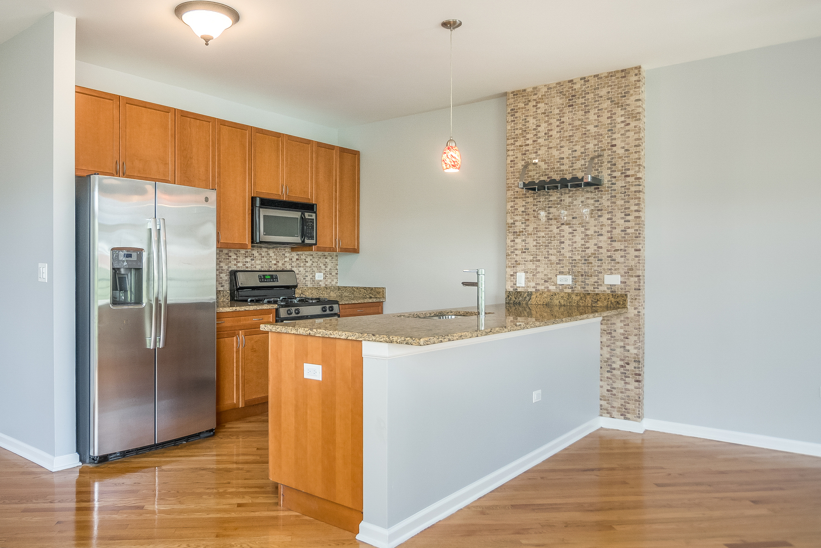 1461 South Halsted Street, Unit 3B Chicago, IL 60607 - Photo 6 of 21 a kitchen with stainless steel appliances granite countertop a refrigerator a stove and a sink with wooden floor