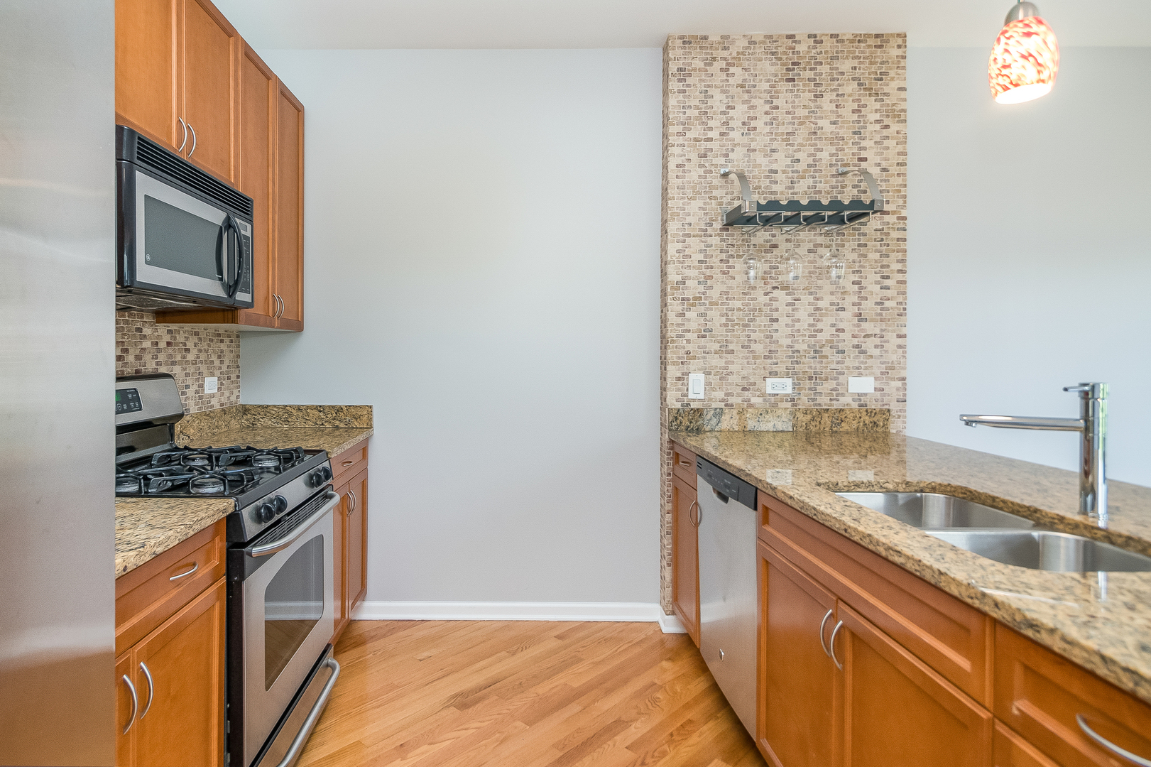 1461 South Halsted Street, Unit 3B Chicago, IL 60607 - Photo 7 of 21 a kitchen with granite countertop a sink stove and microwave