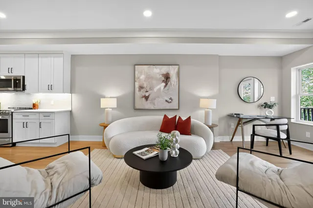 a living room with furniture kitchen view and a potted plant