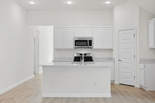 a kitchen with stainless steel appliances granite countertop a sink and a stove