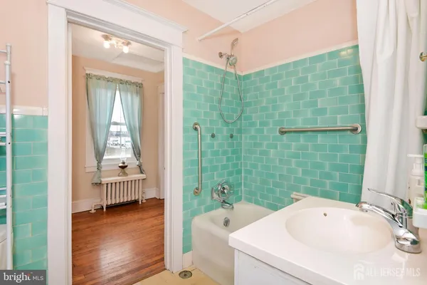 a bathroom with a tub sink and mirror