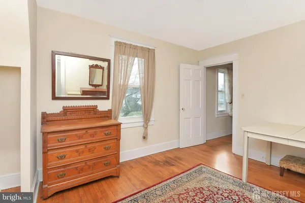 a view of a bedroom with wooden floor and cabinet