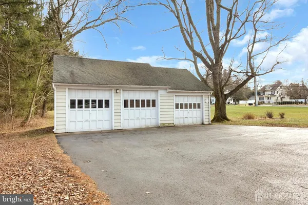 a view of a house with a big yard and large tree
