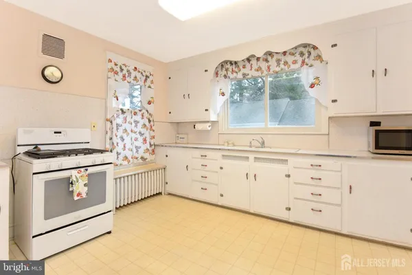 a kitchen with white cabinets and white appliances
