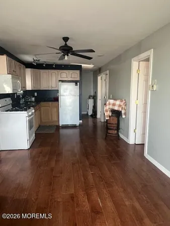 a kitchen with granite countertop a sink cabinets and wooden floor