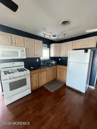 a kitchen with granite countertop a sink a counter top space and cabinets