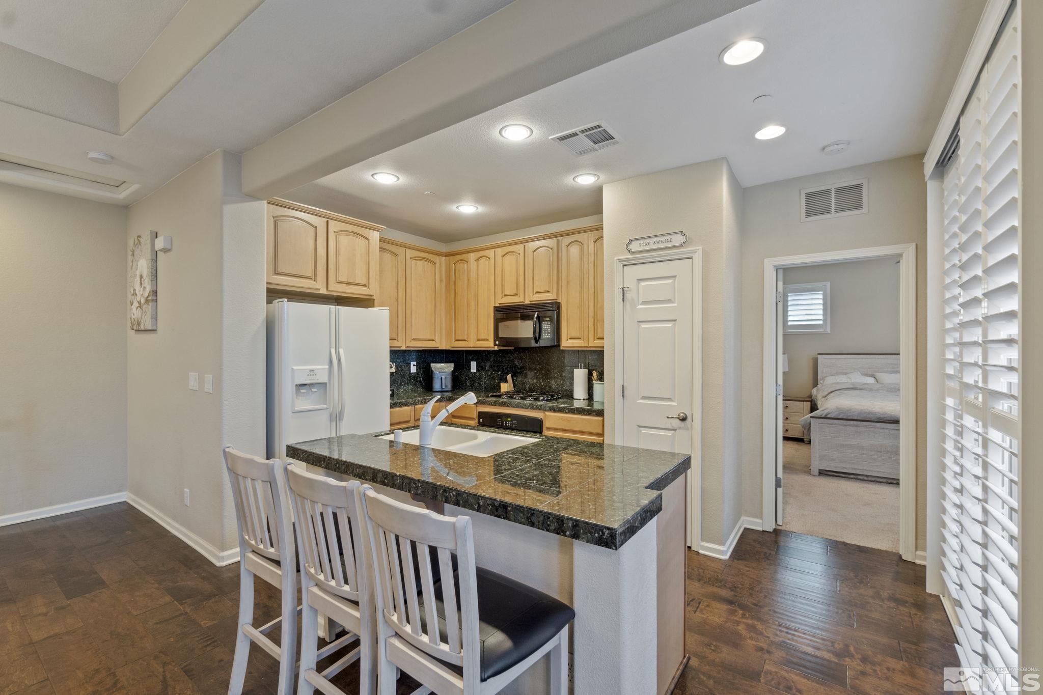 1705 Wind Ranch Road, Unit C Reno, NV 89521 - Photo 16 of 26 a kitchen with refrigerator and cabinets