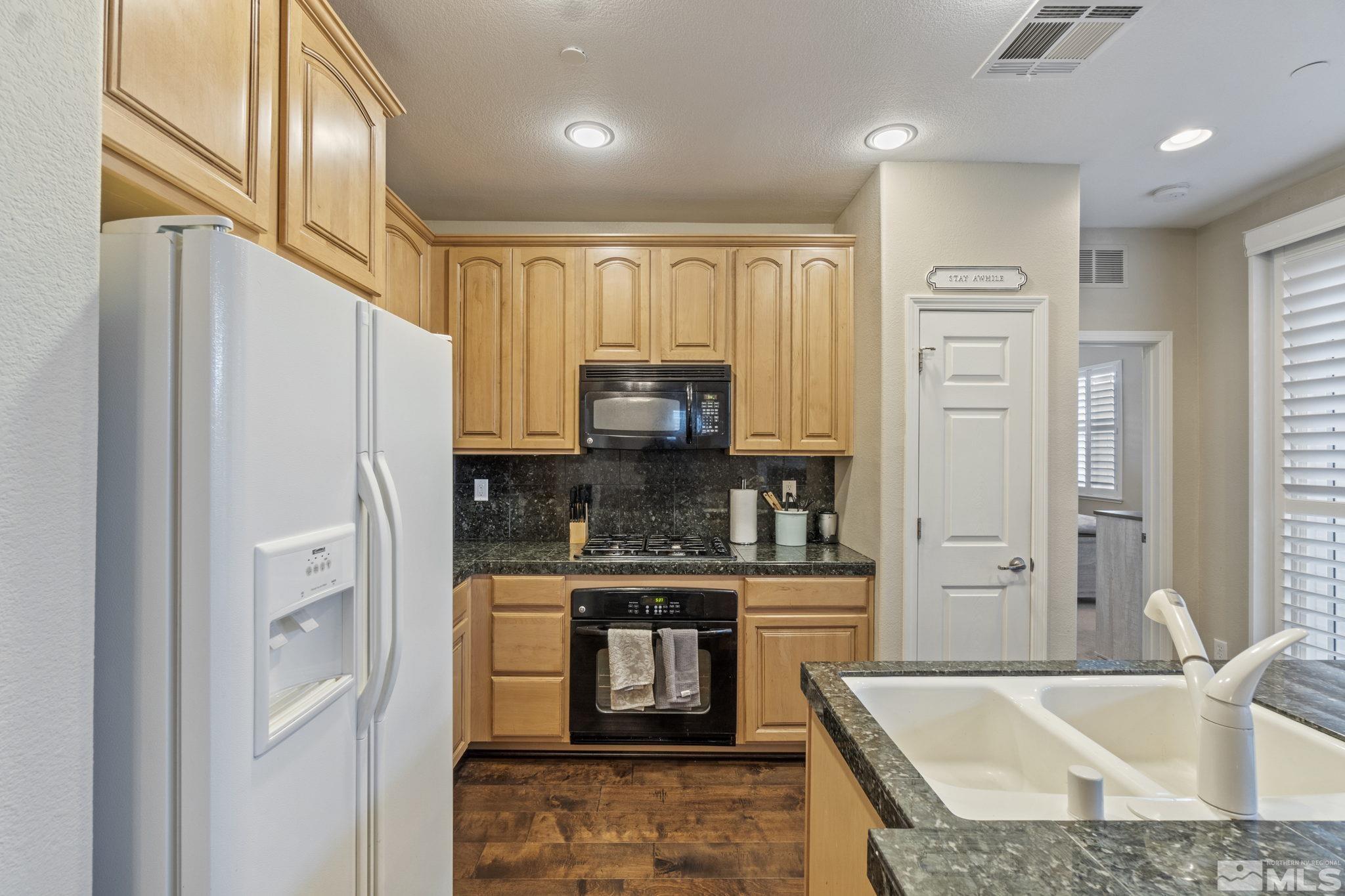 1705 Wind Ranch Road, Unit C Reno, NV 89521 - Photo 17 of 26 a kitchen with stainless steel appliances granite countertop a refrigerator and a sink