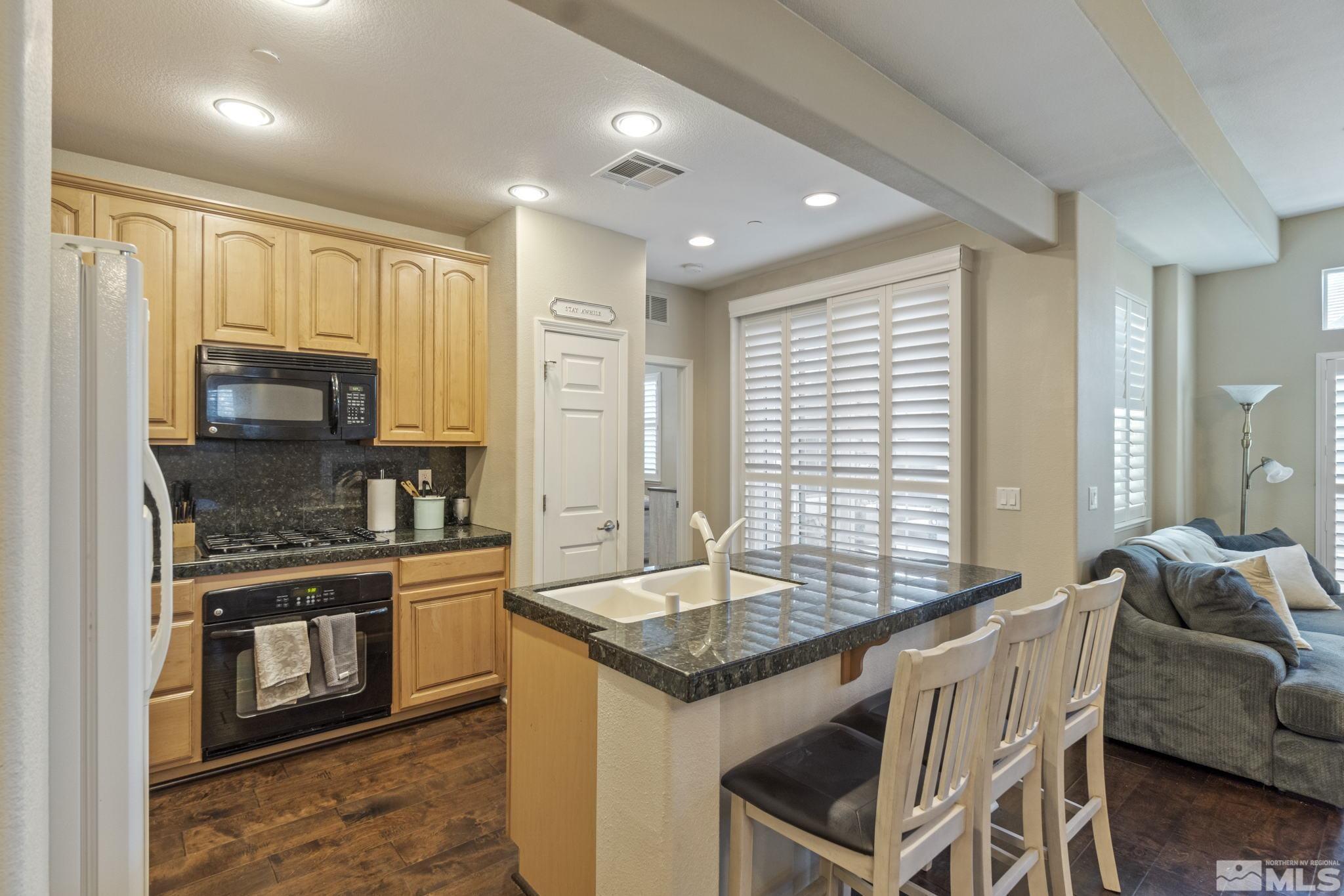 1705 Wind Ranch Road, Unit C Reno, NV 89521 - Photo 18 of 26 a kitchen with granite countertop a stove and a sink