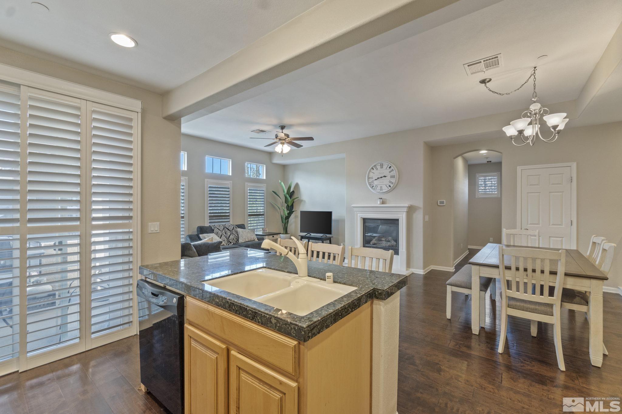 1705 Wind Ranch Road, Unit C Reno, NV 89521 - Photo 20 of 26 a kitchen with granite countertop a stove dining table and chairs
