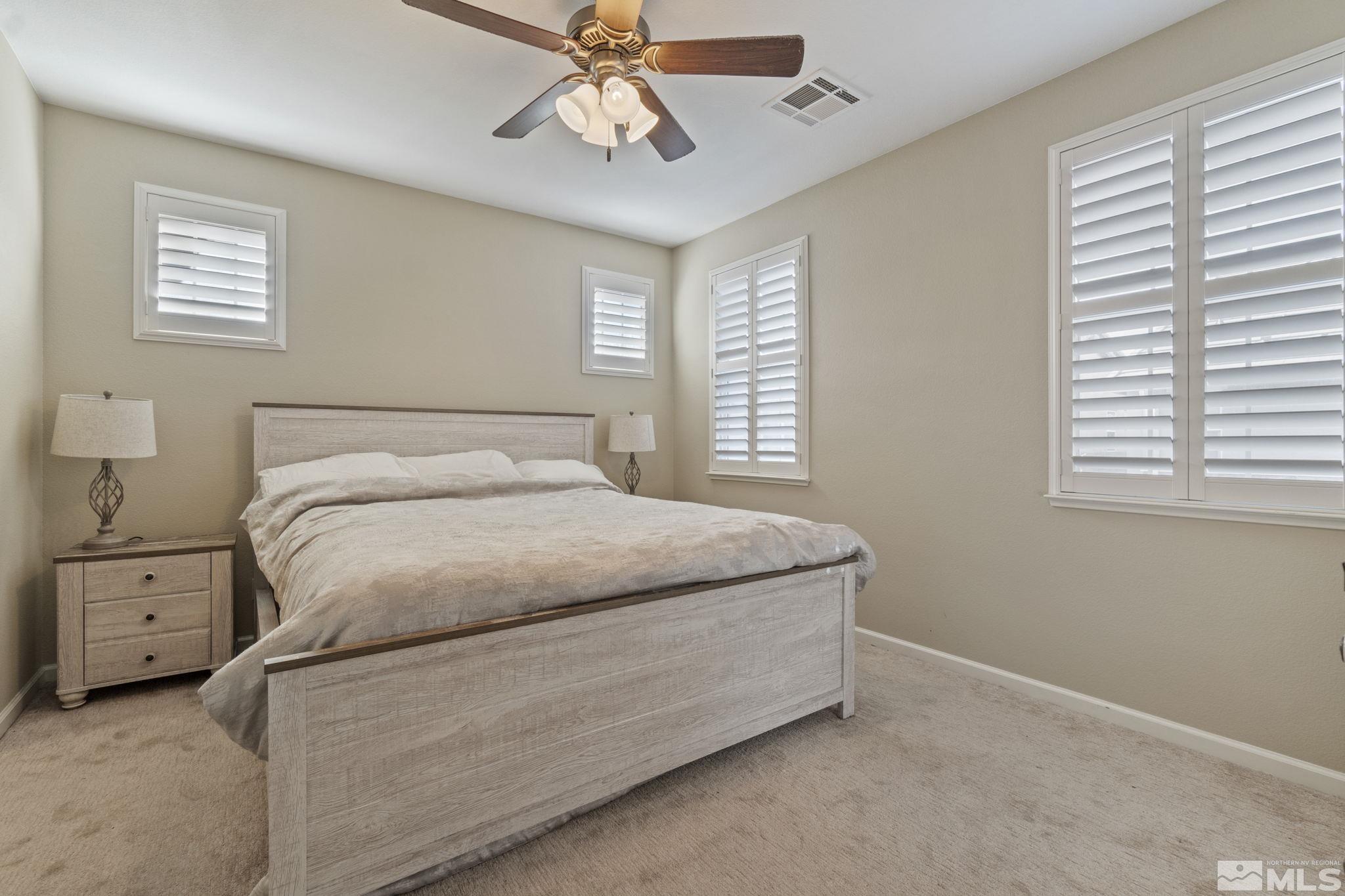 1705 Wind Ranch Road, Unit C Reno, NV 89521 - Photo 21 of 26 a bedroom with a bed and a chandelier