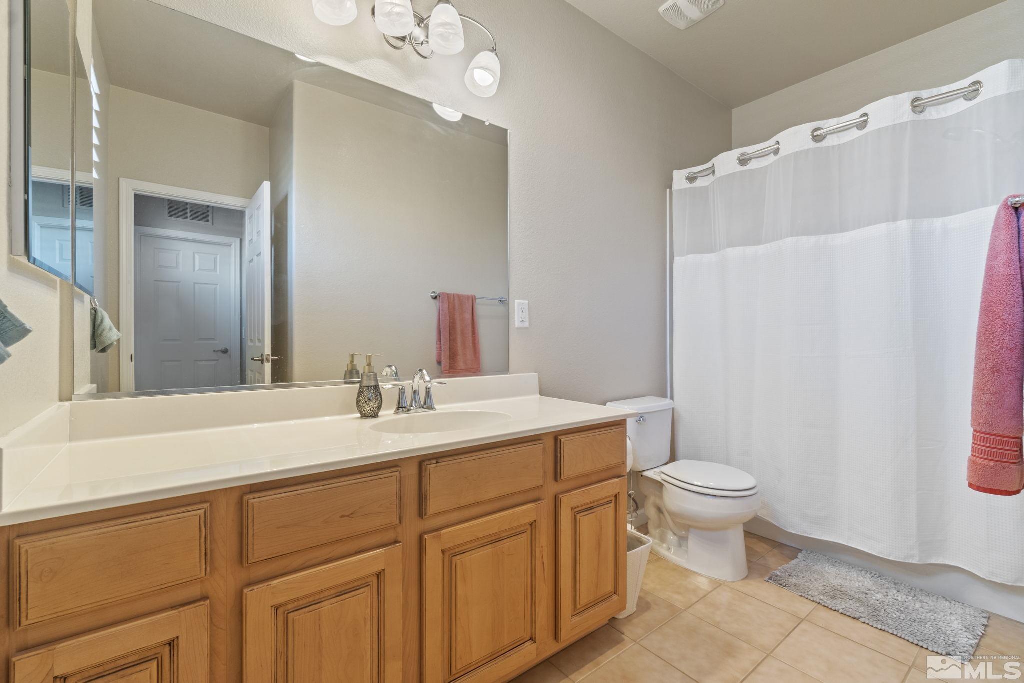 1705 Wind Ranch Road, Unit C Reno, NV 89521 - Photo 25 of 26 a bathroom with a sink a toilet and a mirror