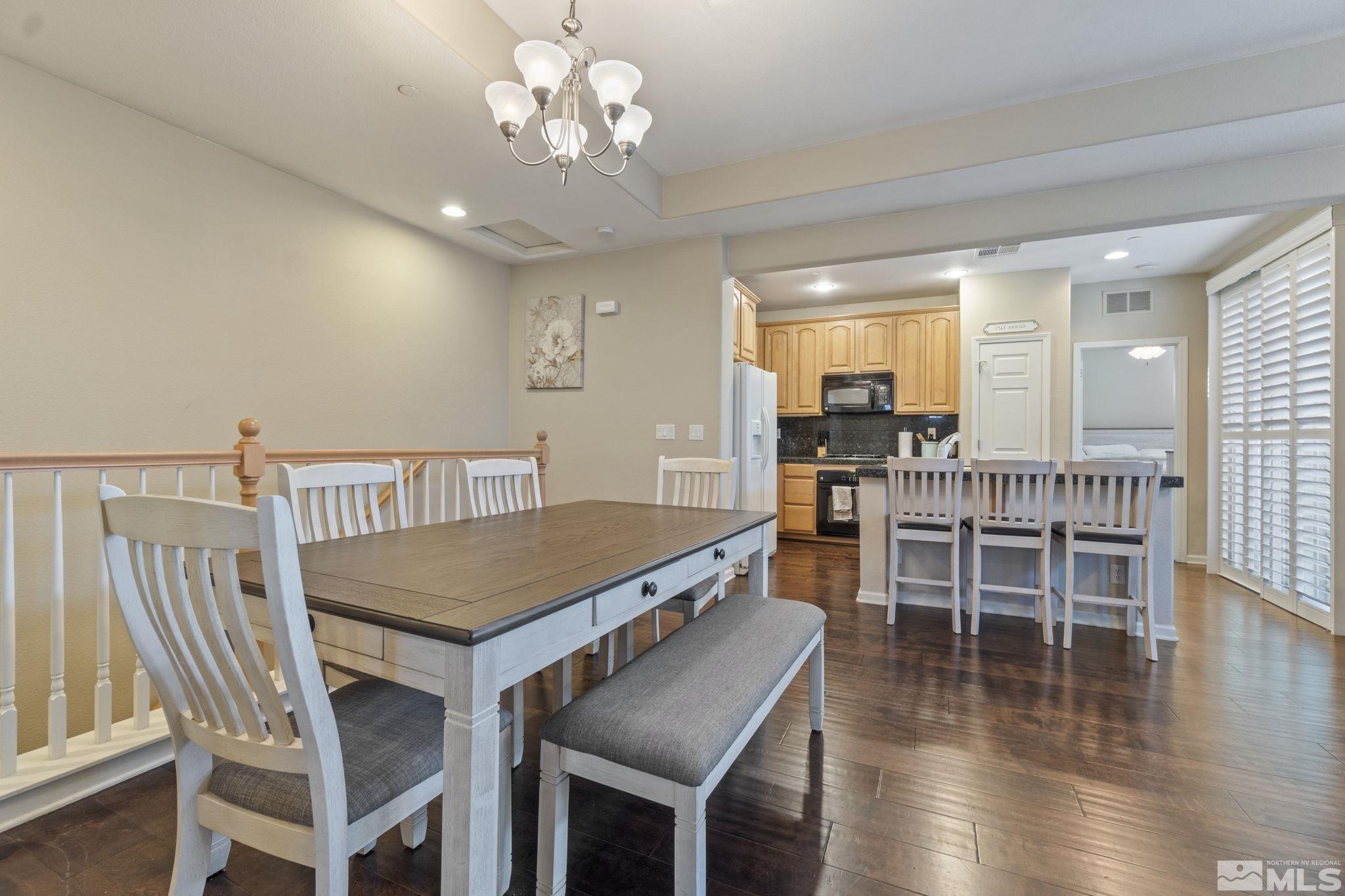 1705 Wind Ranch Road, Unit C Reno, NV 89521 - Photo 8 of 26 a view of a dining room with furniture wooden floor and chandelier