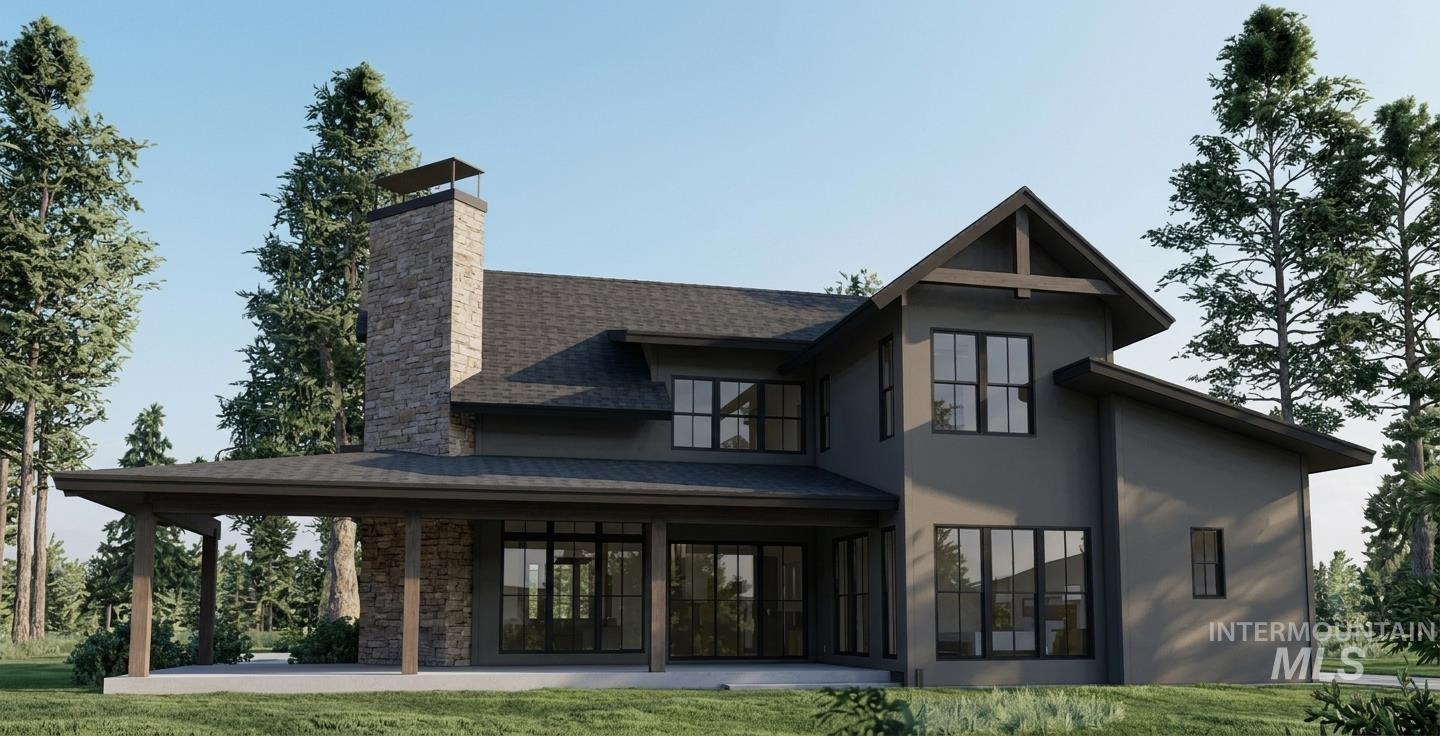 33 River Fork Ranch Lane McCall, ID 83638 - Photo 2 of 5 Modern exterior with a stone chimney, covered patio, multiple large windows, and a dark shingled roof