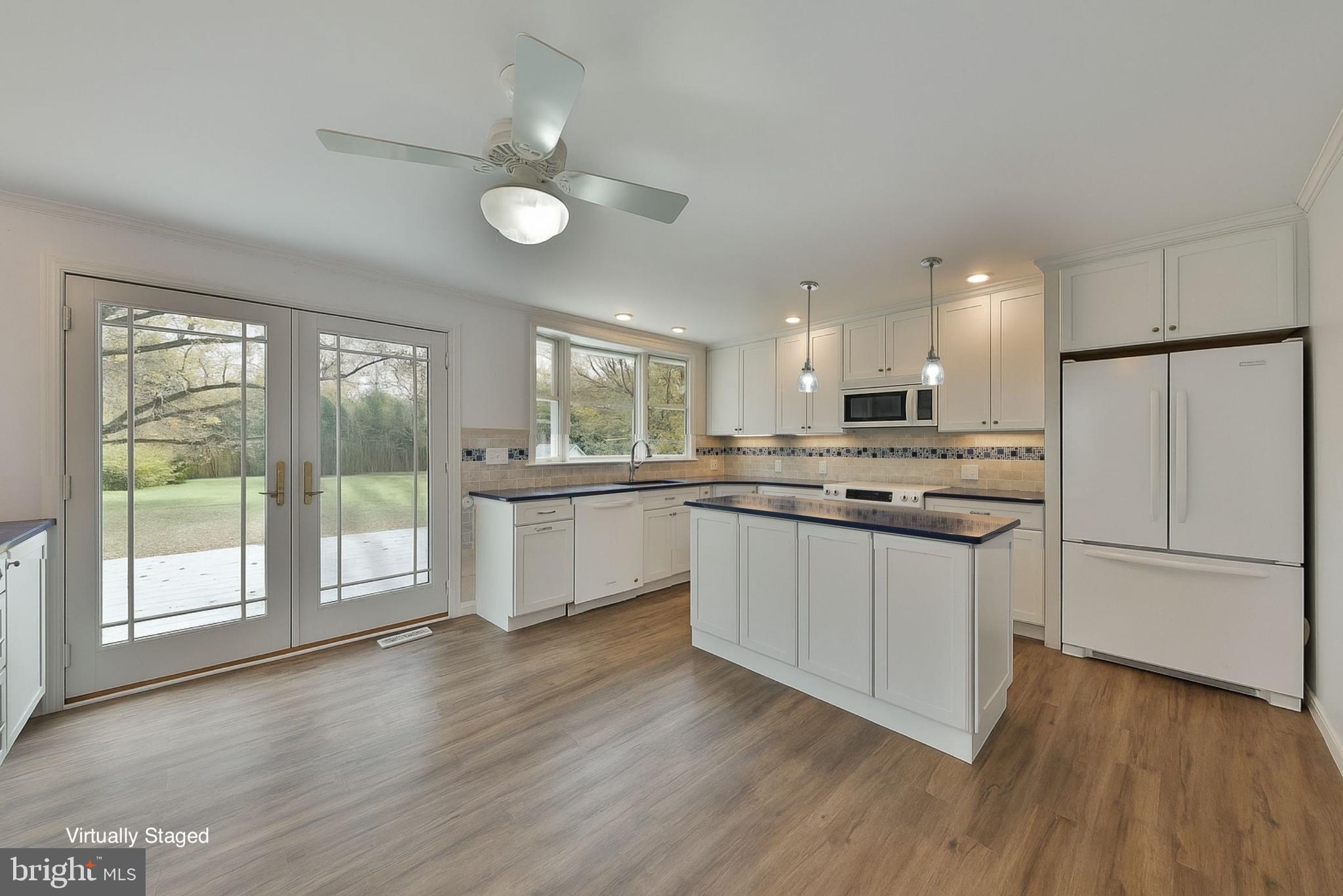 312 East Mill Road Flourtown, PA 19031 - Photo 17 of 36 a kitchen with stainless steel appliances granite countertop a refrigerator a sink dishwasher a stove and white cabinets with wooden floor