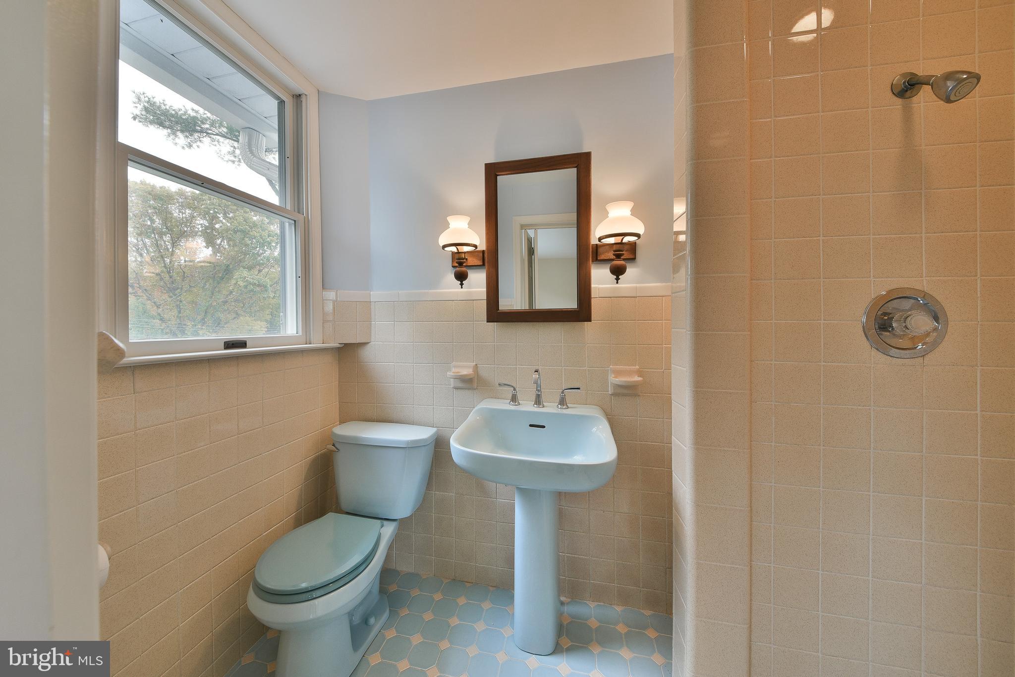 312 East Mill Road Flourtown, PA 19031 - Photo 26 of 36 a bathroom with a sink mirror toilet and a window