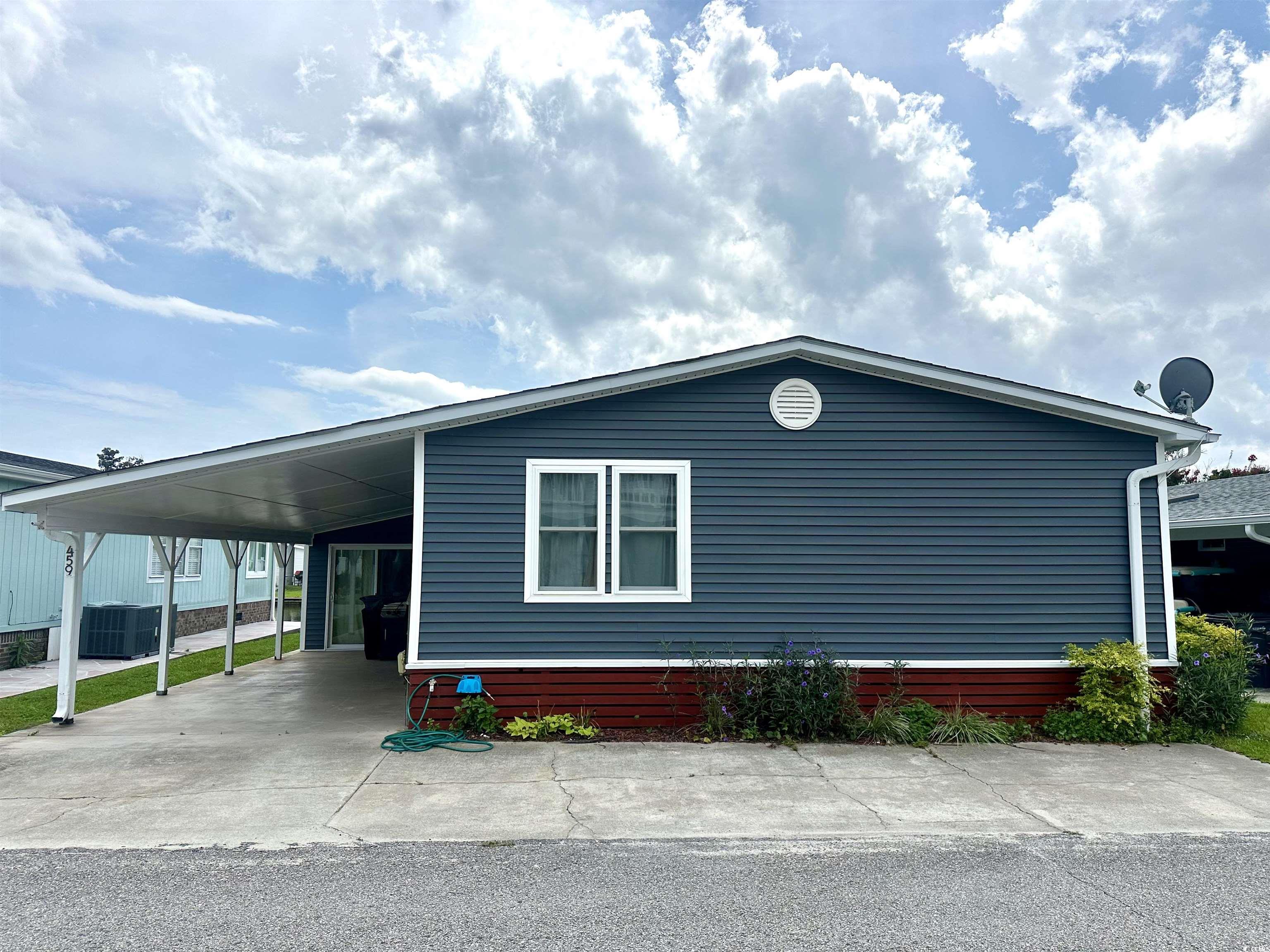 View of side of home with a carport and cooling un
