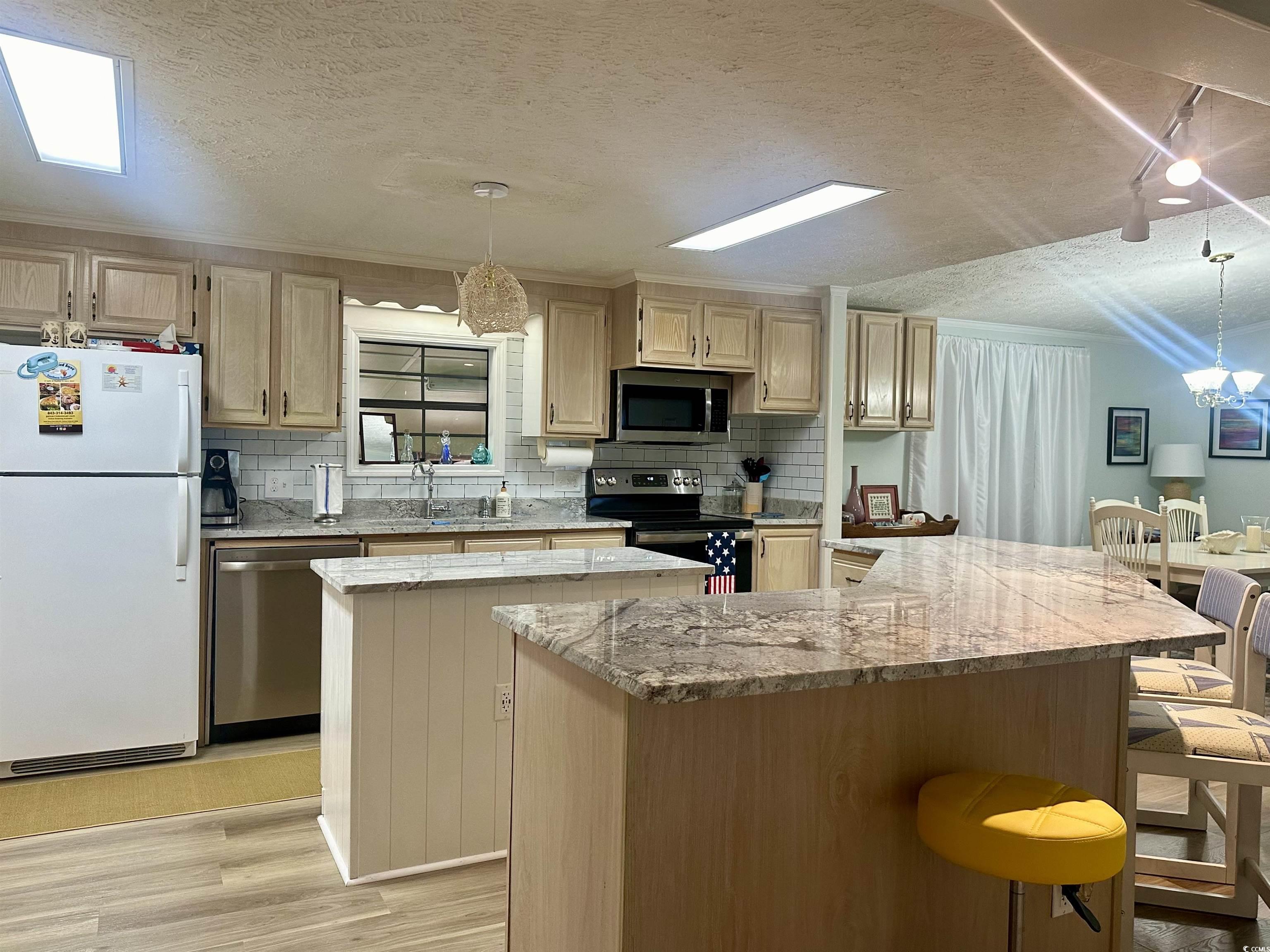 459 Meadowlark Surfside Beach, SC 29575 - Photo 18 of 36 Kitchen with hanging light fixtures, light hardwoo
